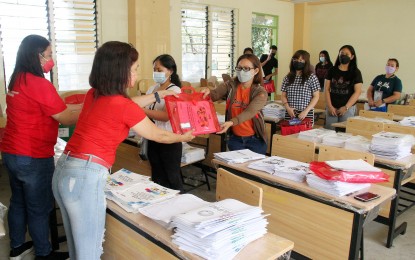 <p><strong>ALTERNATE.</strong> Teachers of Dasmariñas Integrated High School in Cavite province hand over self-learning modules to parents in this undated photo. Learning modules are among the options implemented by the Department of Education during the Covid-19 pandemic and the hot dry season. <em>(PNA file photo) </em></p>