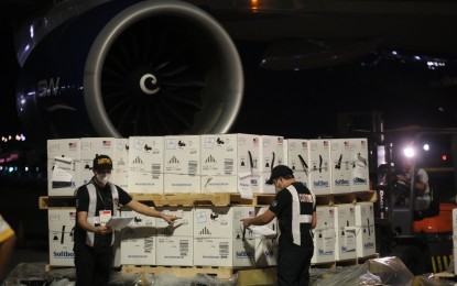 <p><strong>NEW DONATIONS.</strong> Customs personnel inspect the shipment of 3,436,290 doses of the Pfizer Covid-19 vaccine that arrived at the Ninoy Aquino International Airport Terminal 2 via a Silkway Airlines flight on Thursday night (Feb. 10, 2022). The jabs were donated by the United States government through the COVAX Facility. <em>(PNA photo by Avito C. Dalan)</em></p>