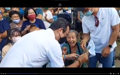 <p><strong>NATIVE SON.</strong> An elderly relative shows photos to presidential bet Francisco “Isko Moreno” Domagoso in Lavezares, Northern Samar on Tuesday (Feb. 15, 2022). Domagoso said his mother was born in nearby Allen town.<em> (Screengrab from Isko Moreno Domagoso Facebook)</em></p>