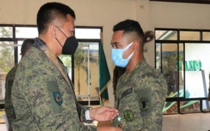 <p><strong>COMMENDATION</strong>. Brig. Gen. Inocencio Pasaporte (left), commander of 303rd Infantry Brigade, pins the Military Commendation Medal on a Philippine Army reservist who contributed to the relief and rescue efforts in the aftermath of Typhoon Odette, during the rites held in Sipalay City, Negros Occidental on Sunday. “We recognize their efforts and commitment in assisting the affected Negrenses in the cities of Kabankalan and Sipalay,” Pasaporte said in a statement on Tuesday (Feb. 15, 2022).<em> (Photo courtesy of 303rd Infantry Brigade, Philippine Army)</em></p>