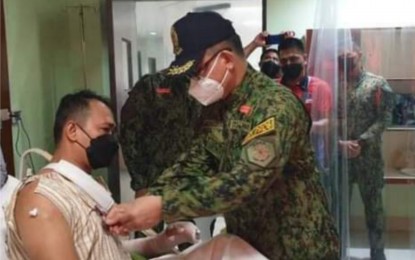 <p><strong>AWARD</strong>. Brig. Gen. Flynn Dongbo, director of Police Regional Office-Western Visayas, awards the Philippine National Police Wounded Personnel Medal to Lt. Charles Richard Casalan, deputy chief of Binalbagan Municipal Police Station, at a hospital in Bacolod City on Monday (Feb. 14, 2022). Casalan was injured when NPA rebels detonated an anti-personnel mine by the roadside while his team was responding to a call for assistance on February 13. <em>(Photo courtesy of Negros Occidental Police Provincial Office)</em></p>