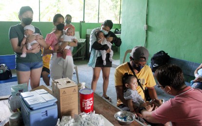 <p>PROTECTED’. Jennifer Alejos (right), a nurse from City Health Office of the City of Dasmarinas, Cavite, administers oral polio and measles vaccines to a baby girl at the village hall in Barangay Salitran 3 on Wednesday (Feb. 16, 2022). Under the program, oral polio and measles vaccines are given to all children 5 years old and below. (PNA file photo)</p>