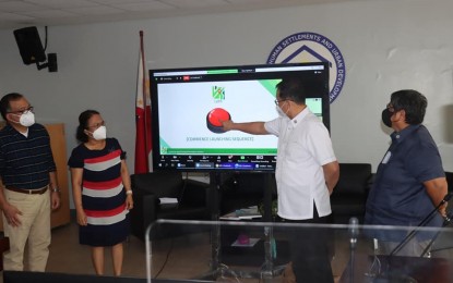 <p><strong>LAND USE SYSTEM.</strong> Department of Human Settlements and Urban Development (DHSUD) Secretary Eduardo del Rosario (center) leads the launch of Land Use and Zoning Information System (LUZIS) at its Central Office in Quezon City during its third founding anniversary celebration on Tuesday (Feb. 15, 2022). Del Rosario described the official rollout of LUZIS as "another monumental step towards a transparent, efficient, and data-driven DHSUD." <em>(Photo courtesy of DHSUD)</em></p>