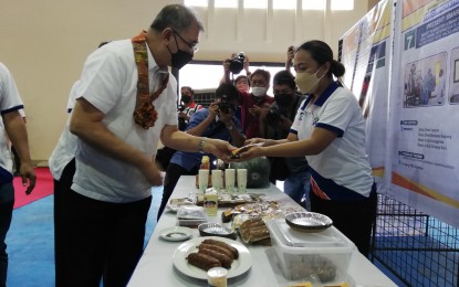 <p><strong>PRODUCT CHECK</strong>. Department of Science and Technology (DOST) Secretary Fortunato de la Peña (left) checks on the products of the Food Innovation Center at the Pangasinan State University (PSU) in Bayambang town, Pangasinan on February 17. De la Peña also inspected the equipment given by DOST to PSU. <em>(Photo by Hilda Austria)</em></p>