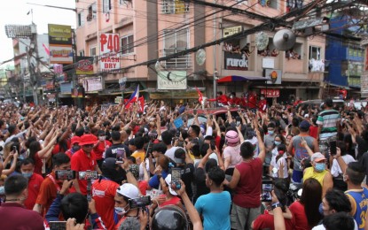 <p><strong>MASS GATHERING.</strong> The convoy of presidential aspirant Ferdinand Marcos Jr. inches its way through a crowd in Tondo, Manila on Feb. 20, 2022. Campaign motorcades in Metro Manila are allowed on major roads only on weekends. <em>(PNA photo by Avito Dalan)</em></p>