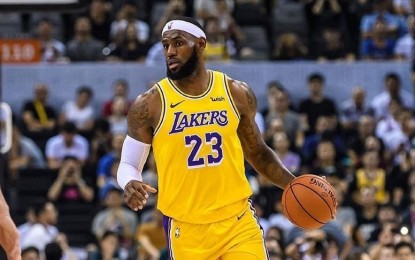 Los Angeles Lakers' LeBron James waves to fans as he is honored during the  first half of an NBA basketball game against the Philadelphia 76ers in Los  Angeles, Wednesday, March 23, 2022.