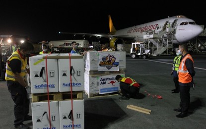 <p><strong>VAX FROM 'DOWN UNDER'</strong>. Airport personnel inspect the shipment of 293,670 doses of Pfizer Covid-19 vaccine for adults donated by the Australian government through the United Nations Children's Fund (UNICEF) at the Ninoy Aquino International Airport (NAIA) Terminal 3 on Monday night (Feb. 21, 2022). Malacañang on Tuesday thanked the Australian government for its unwavering support to the country's Covid-19 pandemic response and other humanitarian assistance to the Philippines. <em>(PNA photo by Avito Dalan)</em></p>
