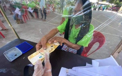 <p><strong>SOCIAL PENSION PAYOUT.</strong> An indigent senior citizen (right) receives a cash grant handed over by a social welfare worker in Soccsksargen (Region 12) in this undated photo. On Tuesday (Feb. 22, 2022), the Department of Social Welfare and Development in Region 12 commenced this year's handing out of financial grants to indigent elders across the region this year. <em>(Photo courtesy of Ryan Balanza / DSWD-12)</em></p>