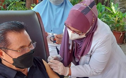 <p><strong>BOOSTER VACCINE.</strong> BARMM Chief Minister Ahod Ebrahim gets his booster jab in public in this undated photo at his house in Maguindanao to convince other Bangsamoro people it is safe and effective. Dr. Elizabeth Samama, Maguindanao health chief, administered the shot.<em> (Photo courtesy of IPHO-Maguindanao)</em></p>