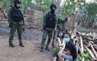 <p><strong>NABBED.</strong> Harlyn “Karyll” Balora (seated) was arrested in a joint military and police operation last Saturday (Feb. 19, 2022) at Sitio Montara, Barangay Kamang-kamang in Isabela, Negros Occidental. The troops intended to serve an arrest warrant for homicide to CPP-NPA leader Romeo Nanta alias “Juanito Magbanua”, who evaded arrest, but instead found Balora, his constant companion, in the area possessing firearms with ammunition, and explosives. <em>(Photo courtesy of 303rd Infantry Brigade, Philippine Army)</em></p>