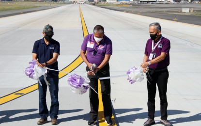 <p><strong>UPGRADE.</strong> (From left) Defense Secretary Delfin Lorenzana, Transportation Secretary Arthur Tugade, and Manila International Airport Authority General Manager Ed Monreal lead the inauguration of the newly repaired and upgraded taxiways at the Ninoy Aquino International Airport on Friday (Feb. 25, 2022). The PHP1-billion upgrade will ensure the efficient use of the runway, quicker landing and exit, and quicker release of flights taking off. <em>(PNA photo by Jess M. Escaros Jr.)</em></p>