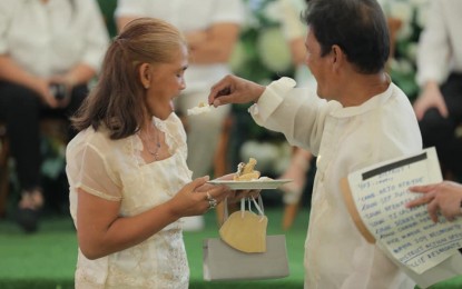 <p><strong>HUSBAND AND WIFE</strong>. A couple does a traditional cake-cutting after exchanging wedding vows in a ceremony hosted by Quezon City’s government’ Kasalang Bayan program in February. A total of 6,233 indigent couples availed themselves of the city’s month-long program. <em>(Photo grabbed from QC government Facebook page)</em></p>