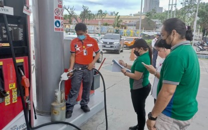 <p><strong>FUEL PUMP CALIBRATION</strong>. DOE-Visayas Energy Industry Management Division inspectors, Engineers Renelyn Estiya and Evander Diola, check the calibration of fuel pump machines of Caltex Landers in Mabolo, Cebu City on Friday (March 4, 2022). DOE-Visayas Director Russ Mark Gamallo said there is enough fuel and LPG supply for Central Visayas, as assured by oil companies, amid the conflict in Ukraine. <em>(PNA photo by John Rey Saavedra)</em></p>