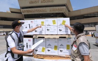 <p><strong>VACCINES.</strong> Bureau of Customs and Department of Health personnel inspect some of the shipment of 3,999,060 doses of Pfizer Covid-19 vaccine at the NAIA Terminal 1 in Parañaque City on March 7, 2022. The vaccines are donated by the US government through the COVAX facility. <em>(PNA photo by Joey O. Razon)</em></p>