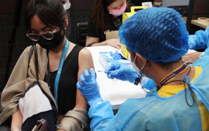 <p><strong>JAB AT JOB SITE.</strong> An employee of a business outsourcing company in Makati City gets her Covid-19 vaccine booster shot on Tuesday (March 8, 2022). The event is a prelude to the fourth edition of the national vaccination drive "Bayanihan, Bakunahan" on March 10 to 12.<em> (PNA photo by Jess M. Escaros Jr.)</em></p>