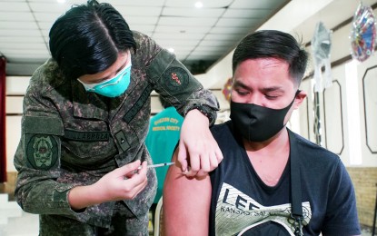 <p><strong>BEST PROTECTION.</strong> 2Lt. Anne Zairell Villabroza, a nurse, administers the Moderna Covid-19 booster shot to Mhontie Mentes at the Philippine Medical Association auditorium in Quezon City on March 10, 2022. The Philippines has achieved its target of fully vaccinating at least 70 million before the end of the Duterte administration. <em>(PNA photo by Ben Briones)</em></p>