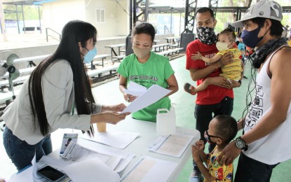 <p><strong>FRESH START.</strong> Couple Ervie Dumasig San Fernando, 29, and Jeric Miranda, 25, along with their two kids and Carlo San Fernando (Ervie's brother) undergo orientation on the “Balik Probinsya, Bagong Pag-Asa” (BP2) program at the BP2 Depot in Quezon City on Wednesday (March 9, 2022). They are among the seven families scheduled to depart Manila to return to the provinces of Camarines Norte, Camarines Sur, and Naga City on the next day. <em>(PNA photo by Robert Oswald P. Alfiler)</em></p>