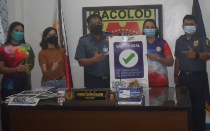 <p><strong>SAFETY SEAL AWARD</strong>. Col. Thomas Joseph Martir (3rd from left), police city director, receives the safety seal certificate awarded to the Bacolod City Police Office for compliance with Covid-19 minimum health protocols from May Theresa Malongayon (2nd from right), local government operations officer VI, after passing the inspection on Friday (March 11, 2022). “As front-liners in the fight against the deadly disease, it has always been the aim of the BCPO to help put an end to this pandemic,” Martir said. <em>(Photo courtesy of Bacolod City Police Office)</em></p>