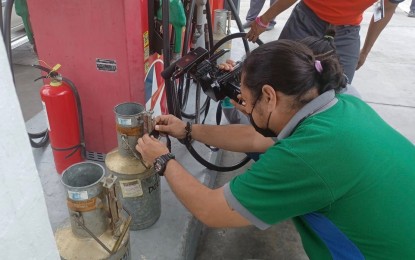 <p><strong>MONITORING.</strong> DOE-Visayas Energy Industry Management Division inspector Evander Diola checks the calibration of the fuel pump machine of a gas station in Cebu City in light of impending oil price increases. DOE-Visayas director Russ Mark Gamallo on Monday (March 14, 2022) issued an advisory urging the public to report hoarding of fuel by industry players to take advantage of the situation to increase their profits. <em>(PNA file photo by John Rey Saavedra)</em></p>
