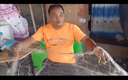 <p><strong>IN NEED OF HELP</strong>. Roger Quibec, a fisherman in Orion, Bataan, shows his worn-out fishing net as he appealed for assistance from the government on Tuesday (March 15, 2022). He asked the government to help them through subsidies and the provision of fishing nets amid the rising fuel prices. <em>(Photo by Ernie Esconde)</em></p>
