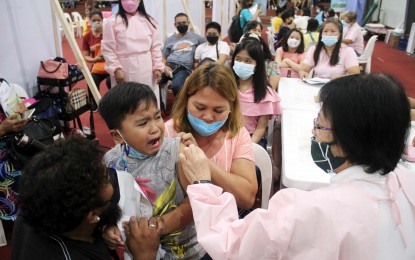 <p><strong>KIDS VACCINATION</strong>. Parents hold their crying 7-year-old son, Asher Jude Agbayani, while being inoculated with the reformulated Pfizer Covid-19 vaccine during the rollout of the jabs for children aged 5 to 11 years old at the Ugnayang La Salle Gymnasium in Dasmariñas City, Cavite on Tuesday (March 15, 2022). Some 381,433 kids under the 5-11 age bracket are now fully vaccinated. <em>(PNA photo by Gil Calinga)</em></p>