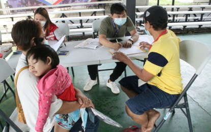 <p><strong>STARTING PROVINCIAL LIFE</strong>. Rommelyn Francisco and her husband Godofredo Lupango get briefed by a Department of Social Welfare and Development personnel on the assistance they can get under the “Balik Probinsya, Bagong Pag-asa (BP2)” Program at the BP2 depot in Quezon City on Monday (March 15, 2022). The couple is bound for Mobo, Masbate province to start a new life. <em>(PNA photo by Robert Oswald Alfiler)</em></p>