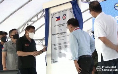 <p><strong>UNVEILING OF NEW MARKER.</strong> President Rodrigo R. Duterte leads the unveiling of the marker of the new Leyte provincial government complex in the town of Palo on Thursday (March 17, 2022). Also in the photo are Senator Christopher Lawrence "Bong" Go (behind the President), Leyte Governor Leopoldo Dominico Petilla (right of the marker), and Housing Secretary Eduardo del Rosario. <em>(Screengrab from RTVM)</em></p>