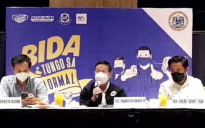 <p><strong>'NEW NORMAL' ROADSHOW.</strong> DOH Secretary Francisco Duque III (center), Secretary Vicencio Dizon (left), the national testing czar, and Mayor Junard Chan attend the “Bida Tungo sa New Normal Roadshow” at a hotel in Lapu-Lapu City on Friday (March 18, 2022). The National Task Force's Coordinated Operations to Defeat Epidemic (CODE) team visit in Cebu was done to encourage Central Visayas local governments to ramp up inoculation of their senior citizens against the coronavirus disease 2019 and satisfy other requirements to transition to Alert Level 1. <em>(Screengrab from PIA-7 video)</em></p>