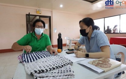 <p><strong>ONE TOWN, ONE PRODUCT.</strong> A small business entrepreneur consults with a Department of Trade and Industry staff in Bayawan City, Negros Oriental on Monday (March 21, 2022) regarding her product for the One Town, One Product program. The DTI-Negros Oriental will be visiting areas to meet with MSMEs to help them with their potential OTOP businesses. <em>(Photo courtesy of DTI-Negros Oriental)</em></p>