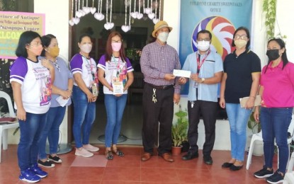 <p><strong>FINANCIAL ASSISTANCE</strong>. Philippine Charity Sweepstakes Office (PCSO) Antique head William Centina (3rd from right), turns over a PHP300,000 check to Provincial Social Welfare and Development Officer (PSWDO) Lazaro Petinglay (5th from left), for the use of the Pagsapupo Center in San Jose de Buenavista on Thursday (March 24, 2022). The assistance is under the Institutional Partnership Program of the PCSO aimed to assist displaced elderlies and children meet their basic needs. <em>(PNA photo by Annabel Consuelo J. Petinglay) </em></p>