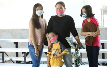 <p><strong>PROVINCE BOUND</strong>. Mieflor Soria and her children Stephanie, Joan, and Yuan happily pose for the “Balik Probinsya, Bagong Pag-asa” Program during the dispatch procedure at the BP2 Depot in Quezon City on Wednesday (March 23, 2022). The family is finally going home to General Santos City after being stuck for two years in Metro Manila due to the Covid-19 pandemic.<em> (PNA photo by Robert Alfiler)</em></p>