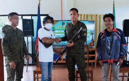 <p><strong>ASG SURRENDERER.</strong> One of nine Abu Sayyaf Group (ASG) militants hands over a rifle to Maj. Gen. Ignatius Patrimonio, the Joint Task Force (JTF)-Sulu commander, following their surrender on Wednesday (March 23, 2022) at the headquarters of the 1102nd Infantry Brigade in Barangay Tagbak, Indanan, Sulu. The surrenderers said they wish to live a peaceful life with their families.<em> (Photo courtesy of JTF-Sulu)</em></p>