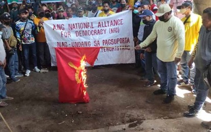 <p><strong>NO TO NPAs</strong>. Members of the National Alliance for Democracy (NAD) burn a flag of the New People's Army in a peace rally Friday (March 25, 2022) in Buug, Zamboanga Sibugay. Simultaneous peace rallies were held in the provinces of Zamboanga Sibugay and Zamboanga del Sur condemning the atrocities of the NPA in the region.<em> (Photo courtesy of the 1st Infantry Division)</em></p>