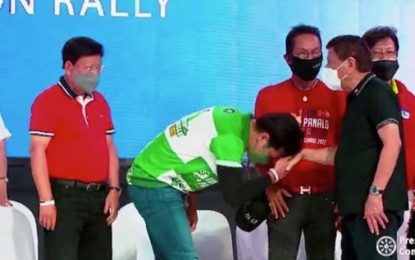 <p><strong>PDP-LABAN RALLY</strong>. Actor Robin Padilla gives the traditional "mano" (kissing of the hand) to President Rodrigo Duterte who graced the PDP-Laban proclamation rally in Barangay Pajac, Lapu-Lapu City on Thursday night (March 31, 2022). In his speech, Duterte thanked the Cebuanos for their support, as he told them that they would not regret it as he delivered his campaign promises before the 2016 national elections.<em> (Screengrab from RTVM video)</em></p>