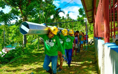 <p><strong>WORKING</strong>. Linemen from Samar are joined by villagers in Maasin City as they work for the restoration of power in some parts of the city more than three months after Typhoon Odette battered the province. As of March 27, 2022, some 34,735 houses are still without electricity. <em>(Photo courtesy of Southern Leyte Electric Cooperative)</em></p>