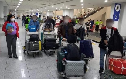 <p><strong>PINOY MIGRANT WORKERS</strong>. Returning overseas Filipino workers (OFWs) in this undated file photo. Departing overseas Filipino workers no longer need to wear full personal protective equipment following a directive from Migrant Workers chief Susan Ople. <em>(File photo from OWWA) </em></p>