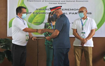 <p><strong>ENVIRONMENTAL WARRIORS.</strong> Department of Environment and Natural Resources-Caraga Director Nonito Tamayo (left) leads the recognition of 17 personnel from Butuan City Police Office Station 2 in a ceremony conducted at the agency’s office in Butuan City on Monday, April 4, 2022. The police personnel are recognized for supporting the implementation of environmental laws in the city. <em>(Photo courtesy of DENR-13)</em></p>