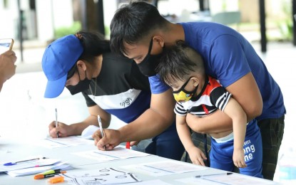 <p><strong>HOME BOUND:</strong> A family completes the requirement before returning to their province in Catanduanes to start a new life through the government’s Balik Probinsya, Bagong Pag-asa program on Thursday (April 7, 2022). Five families or 18 individuals comprise another batch of the BP2 Program beneficiaries. <em>(PNA photo by Robert Oswald Alfiler)</em></p>