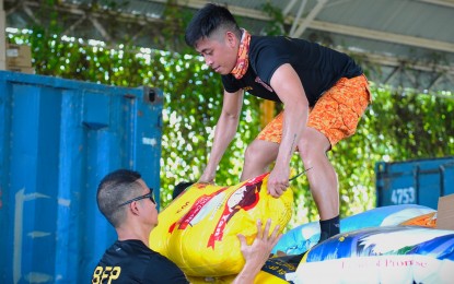 <p><strong>EMERGENCY ASSISTANCE.</strong> Personnel from the Bureau of Fire Protection load sacks of rice to be distributed in the municipalities of Davao Oriental affected by the heavy rains and flooding brought by a due low-pressure area on Wednesday (April 6, 2022). The flooding caused by the weather disturbance displaced 675 individuals in Caraga region and the death of an octogenarian from Cateel municipality.<em> (Photo courtesy of Davao Oriental PIO)</em></p>