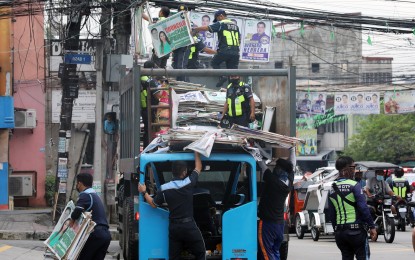 <p><strong>CLEARING OPS.</strong> Quezon City’s “Operation Baklas” personnel remove election campaign materials and paraphernalia in this undated photo. The local governments of Quezon City and Manila have already started the clearing operations. <em>(PNA Photo by Joseph Razon)</em></p>