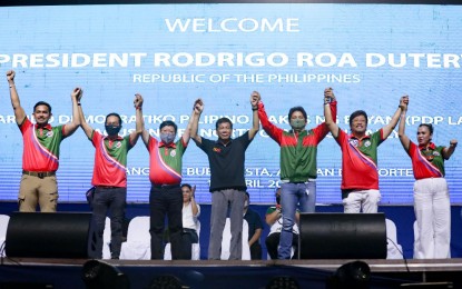 <p><strong>POLITICAL DYNASTY.</strong> President Rodrigo Roa Duterte raises the hands of Partido Demokratiko Pilipino Lakas ng Bayan senatorial aspirants during the campaign rally of PDP Laban at the BECES Grounds in Buenavista, Agusan del Norte on Tuesday (April 12, 2022). Duterte said the dominance of political dynasty would continue because it is still being backed by no less than the Filipino people.<em> (Presidential photo by Karl Alonzo)</em></p>