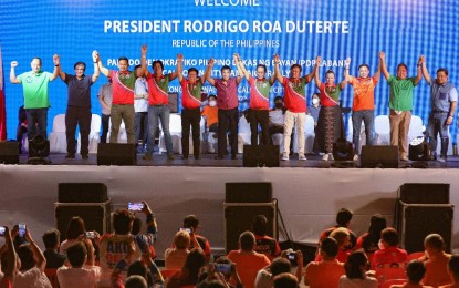 <p><strong>PDP-LABAN RALLY</strong>. President Rodrigo Duterte raises the hands of Partido Demokratiko Pilipino-Lakas ng Bayan (PDP-Laban) senatorial aspirants and guest candidates during the PDP-Laban campaign rally on Congressional Road in Caloocan City on April 19, 2022. He reminded voters to select political bets who have the heart to serve, noting that many candidates tend to forget about the nation and people once elected. <em>(Presidential photo by Simeon Celi)</em></p>