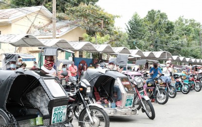 <p><strong>AID TO PUVs</strong>. Tricycle and jeepney drivers in Laoag City get cash and gas vouchers courtesy of the Ilocos Norte government. The program is part of the government's recovery assistance to those in crisis situations. <em>(Contributed photo)</em></p>