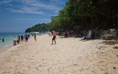 <p><strong>BE COMPLIANT</strong>. Tourists enjoy the white beach of Boracay Island during the Holy Week before the pandemic in 2020. The Department of Tourism said the island should observe the 19,215 daily visitors while its 2018 carrying capacity study is being reviewed by the Department of Environment and Natural Resources. <em>(PNA file photo courtesy of Jun Aguirre)</em></p>