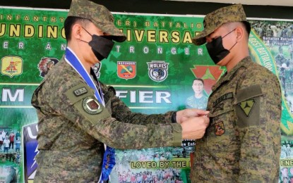 <p><strong>MERIT MEDAL</strong>. Maj. Gen. Benedict Arevalo, commander of the Philippine Army’s 3rd Infantry Division, pins the Military Merit Medal on a soldier of 62nd Infantry Battalion during a ceremony held at the unit’s headquarters in Barangay Libas, Isabela, Negros Occidental on Monday (April 25, 2022). A total of 54 soldiers and one paramilitary trooper received medals for their participation in a series of successful encounters with the CPP-NPA rebels in central and southern Negros earlier this month. <em>(Photo courtesy of 3rd Infantry Division, Philippine Army)</em></p>