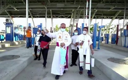 <p><strong>BLESSING</strong>. Cebu Archbishop Jose Palma blesses the tollways at the Cebu-Cordova Link Expressway (CCLEX) during the iconic bridge's opening ceremony on Wednesday (April 27, 2022). Mayor Michael Rama, in his speech during the opening program, urged Cebuanos and visitors to patronize CCLEX and experience its beauty and convenience. <em>(Screengrab from CCLEX video)</em></p>