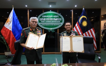 <p><strong>RENEWED COOPERATION.</strong> Commanding General of the Philippine Army Lt. Gen. Romeo Brawner Jr. (right) and Malaysian Chief of Army Gen. Tan Sri Dato’ Seri Zamrose Bin Mohd Zain show copies of the renewed Terms of Reference between the two armies at the Philippine Army headquarters in Fort Andres Bonifacio on April 28, 2022. Ties between the Philippine Army and its Malaysian counterpart go back to September 1994 when the two countries signed a memorandum of understanding on Defense Cooperation. <em>(Photo courtesy of the Philippine Army)</em></p>