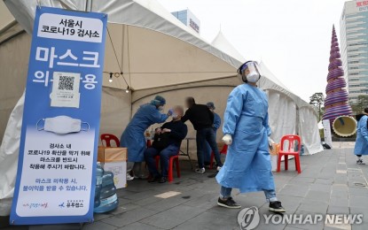 <p>A Seoul citizen takes a Covid-19 test at a makeshift testing center at Cheonggye Stream, central Seoul, on April 24, 2022, amid the slowdown of the Omicron wave. <em>(Yonhap)</em></p>