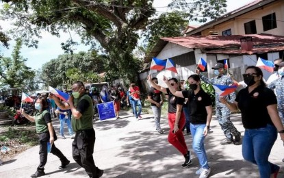 <p><strong>UNITY WALK.</strong> Government agencies, non-government groups, and other the stakeholders participate in the Duterte Legacy Caravan in Manjuyod, Negros Oriental on Sunday (May 2, 2022). During the event, former rebels called out to their former comrades to surrender and avail of the government's services and benefits offered to them.<em> (Photo courtesy of the Negros Oriental Provincial Police Office)</em></p>