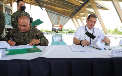 <p><strong>AGREEMENT.</strong> Maj. Gen. Andrew D. Costelo, commander of the 7th Infantry Division, Philippine Army (left), and Lawyer Aristotle B. Batuhan, officer-in-charge, president, and chief executive officer of Bases Conversion and Development Authority (BCDA), sign a partnership agreement to enhance security activities in the New Clark City in Capas, Tarlac on Wednesday (May 4, 2022). As agreed upon, the Citizens Armed Forces Geographical Unit Active Auxiliary Company II (CAA-II) of the 7ID will augment the security operations. <em>(Photo courtesy of BCDA)</em></p>